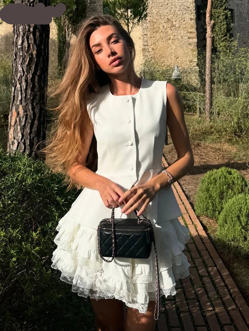 Woman in a white dress holding a black handbag in an outdoor setting