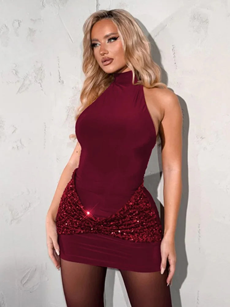 Woman wearing a burgundy dress with a sequin detail against a light background