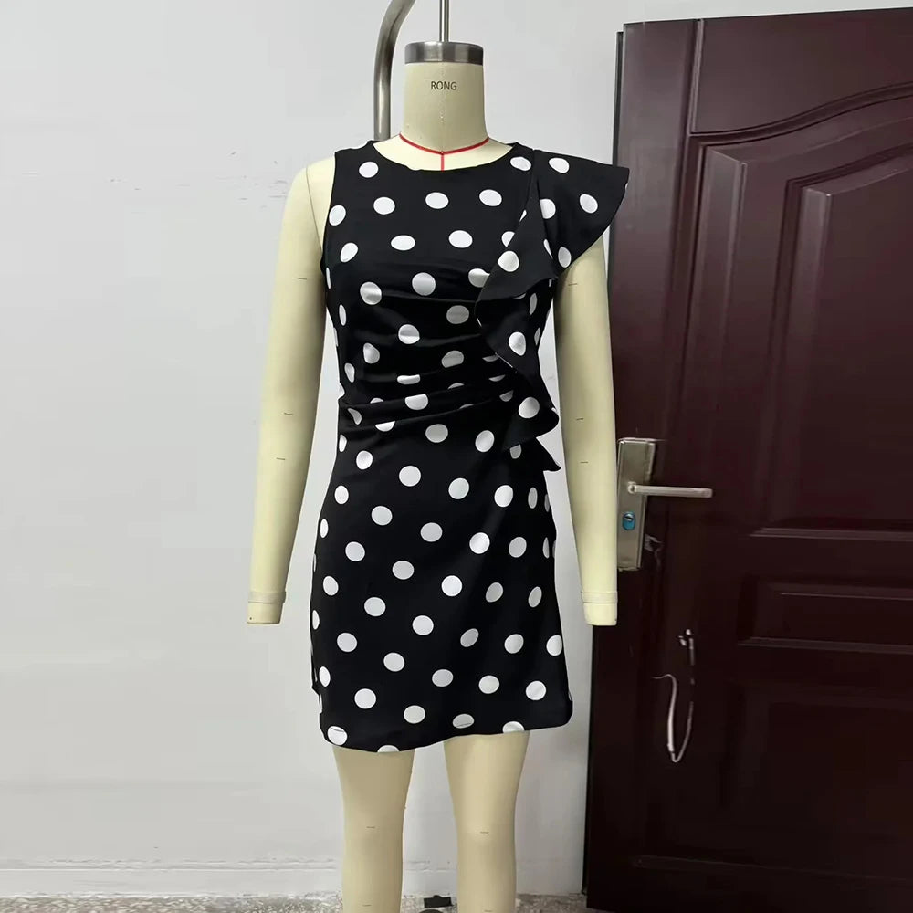 Black dress with white polka dots on a mannequin against a door background