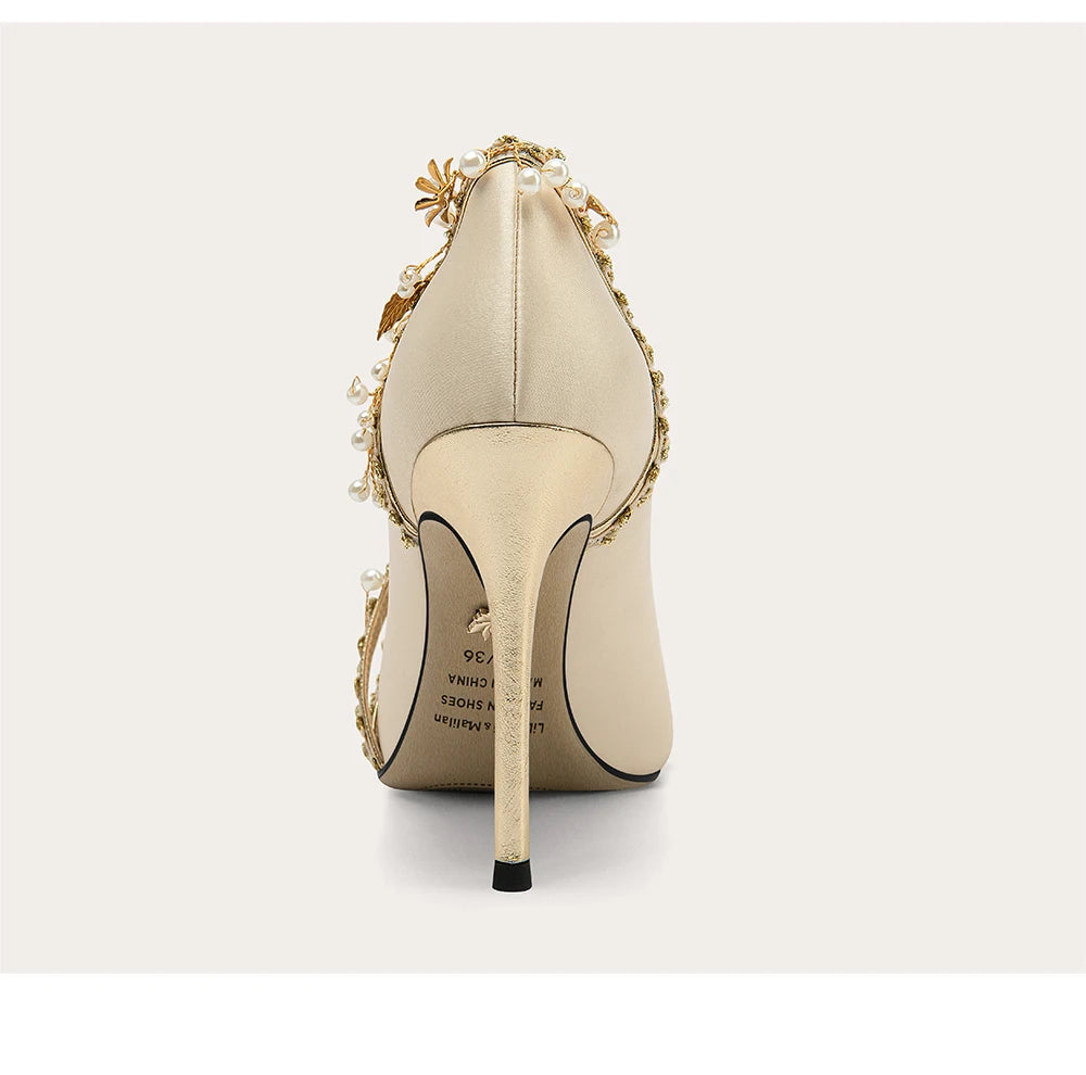 Beige high-heeled shoe with decorative elements on a white background