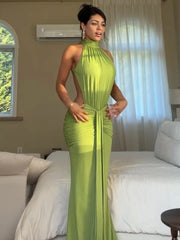 Back view of a model wearing a halter neck draped maxi dress.
