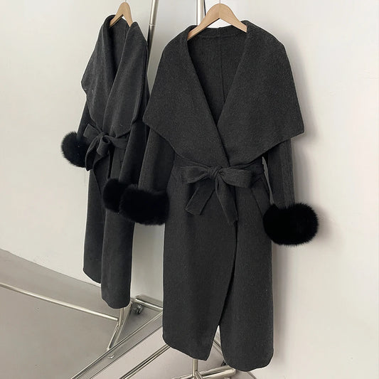 Dark grey wool blend coat with black fur trim and a belted waist.