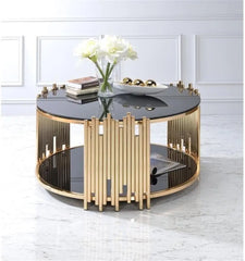 Modern round coffee table with gold and black design in a room setting.
