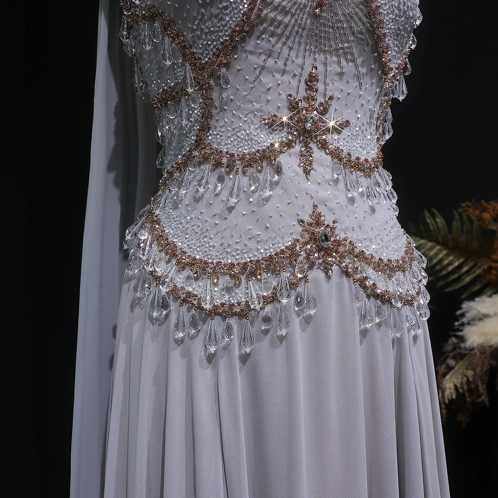 Elegant white dress with intricate beading and embroidery on a dark background