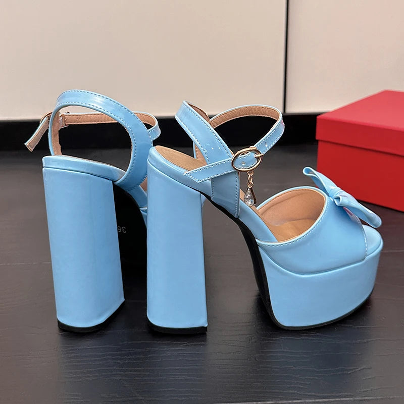 Light blue patent leather platform block heel sandals with bow detail.