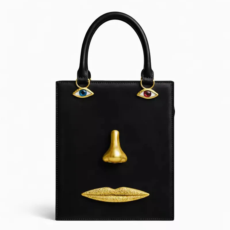 Black sculptural face structured tote bag with top handle.