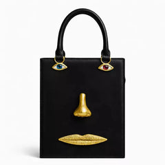 Black sculptural face structured tote bag with top handle.