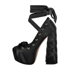 Black platform high heel shoe with ribbon detailing on a white background