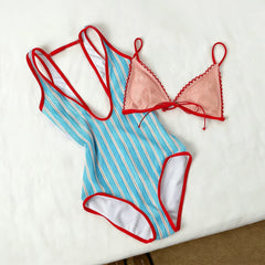Blue and white striped one-piece swimsuit with red trim and a pink lace bikini top