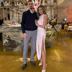 Man and woman posing together in a stylish bar or restaurant setting.