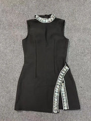 Black sleeveless dress with white embellishments on a gray background
