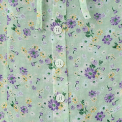 Floral patterned fabric with purple and yellow flowers on a green background
