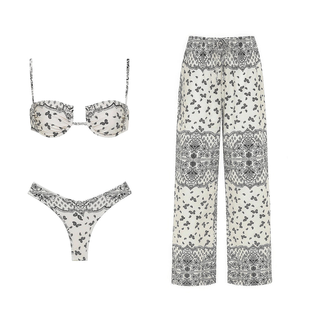 Paisley print bikini top, bikini bottoms, and wide-leg pants arranged flat