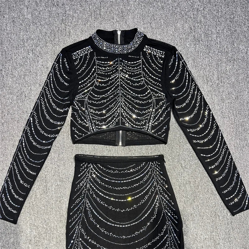 Black outfit with silver rhinestone details on a gray background