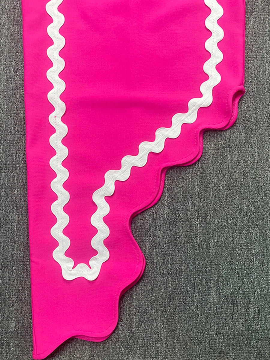 Pink fabric with white scalloped edge on a gray background
