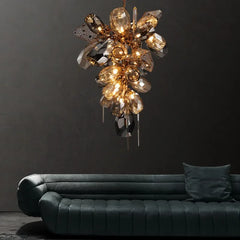 Art Deco chandelier with stained glass globes and iron frame hanging above tufted sofa in elegant living room