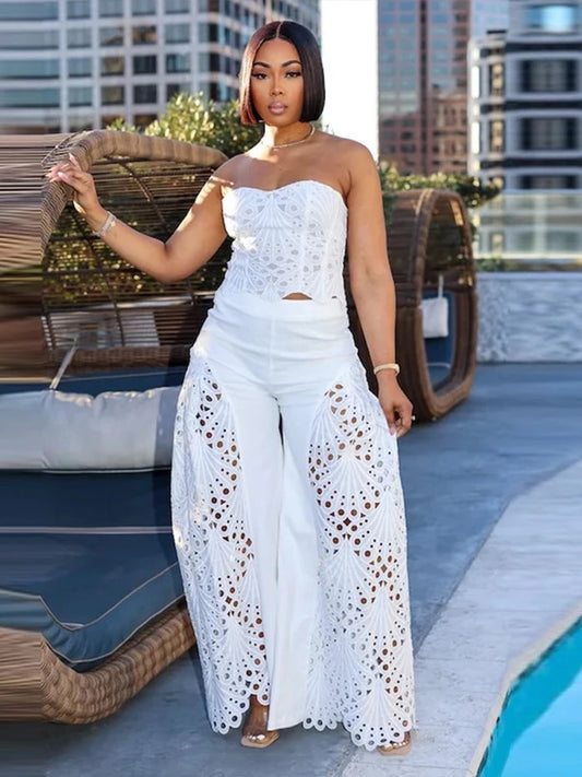 Woman in a white outfit standing by a pool with cityscape background