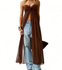 Woman wearing a brown strapless top and light blue jeans on a white background