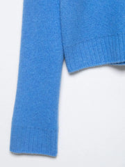 Close-up of a blue sweater sleeve on a white background