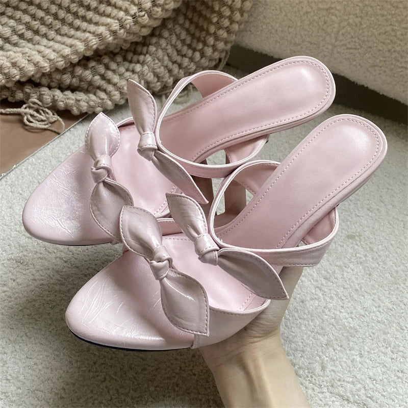 Pink pointed toe mules with a delicate bow detail