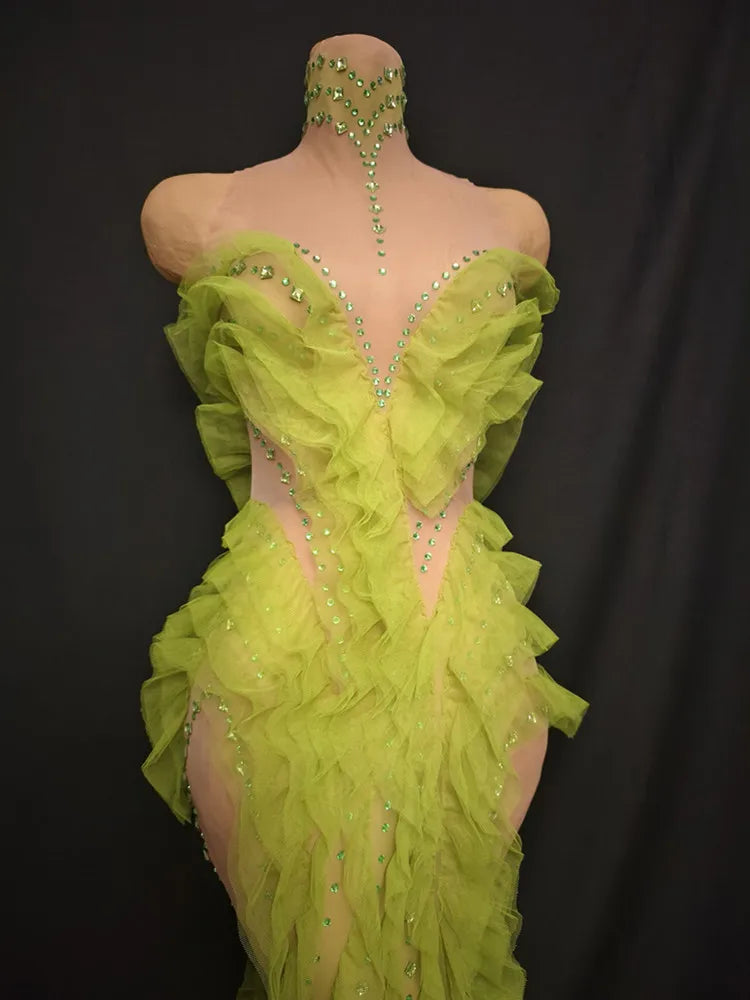 Lime green evening gown with ruffled details on a mannequin against a black background