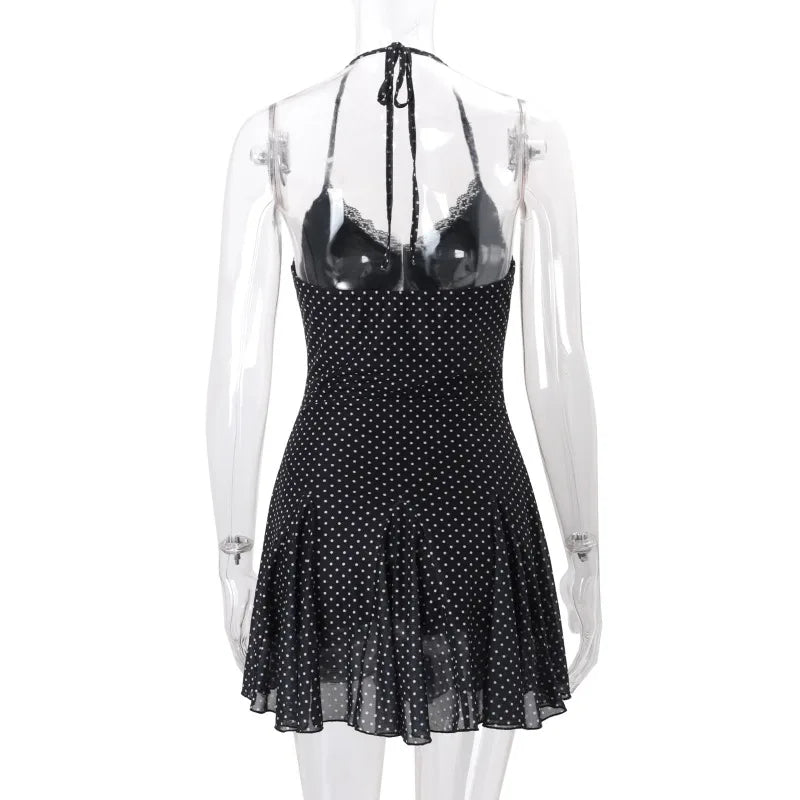 Black polka dot dress with sheer overlay on a mannequin against a white background