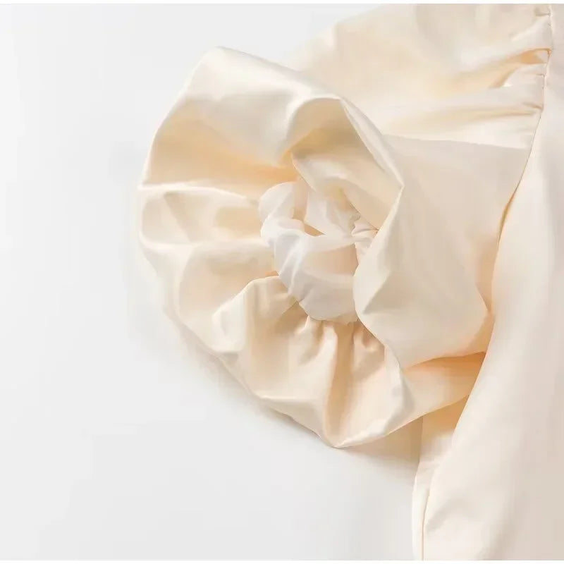 Close-up of beige satin fabric top on a white background