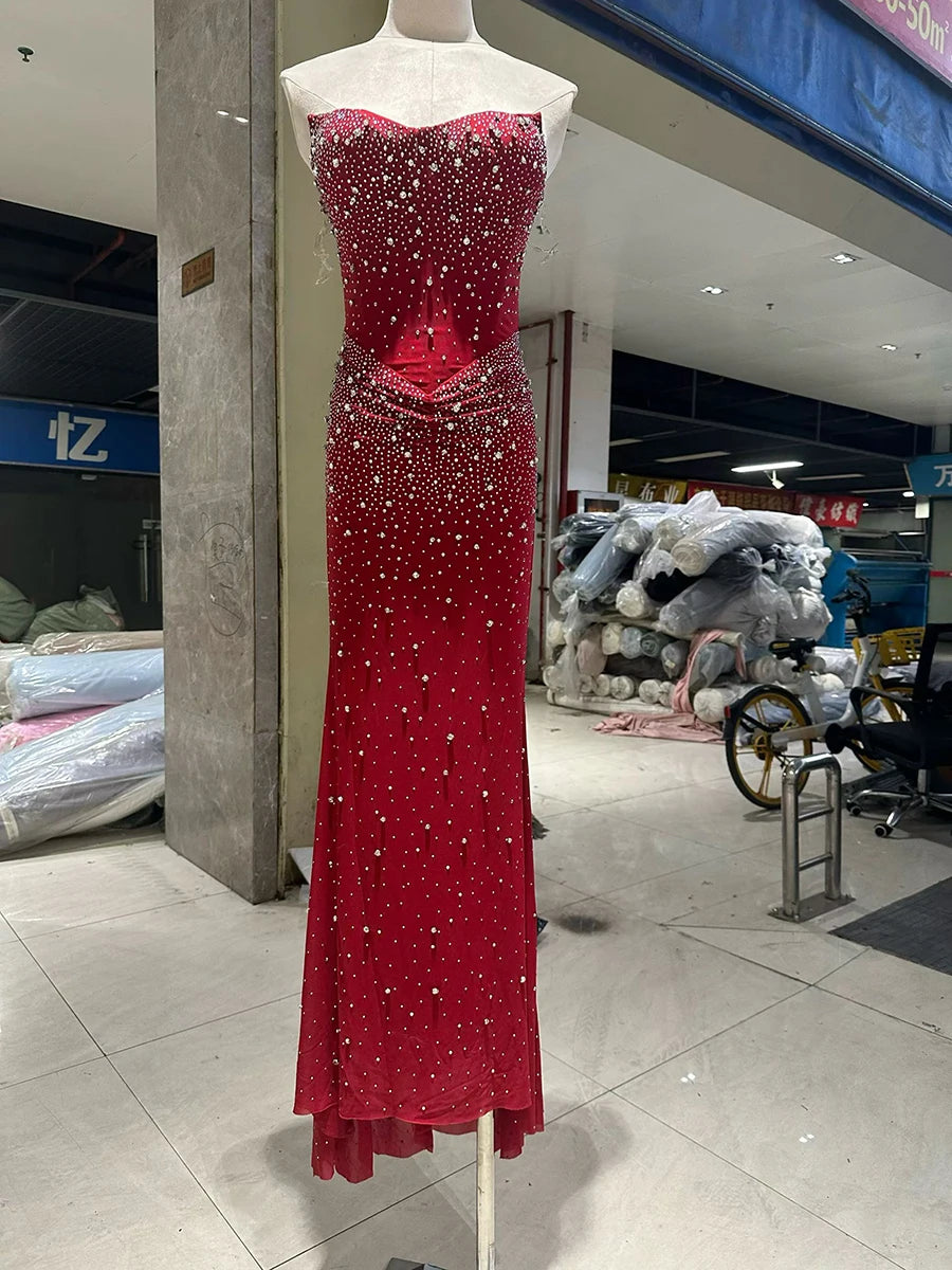 Red evening gown with sequins on a mannequin in an indoor setting.