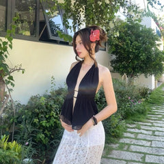 Woman in black top and white skirt standing in a garden