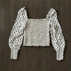 White crochet top with black polka dots on a wooden floor