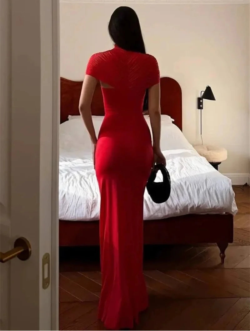 Woman in a red dress standing in a bedroom