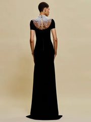 Black evening gown with beaded neckline on a beige background