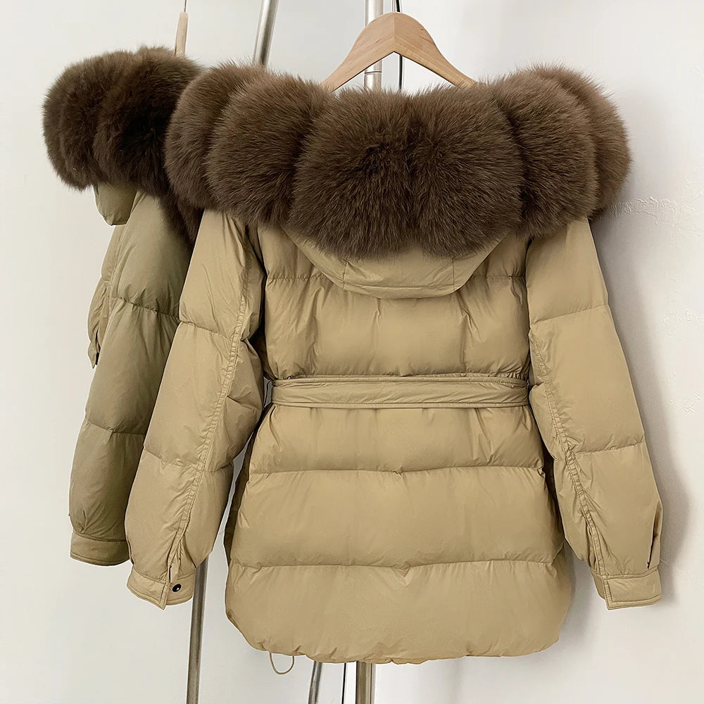 Beige puffer jacket with large fur hood on a wooden hanger 