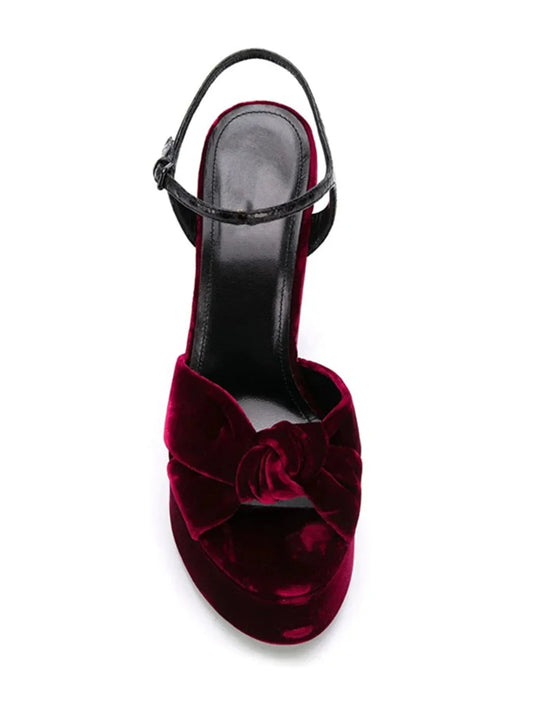 Top-down view of a burgundy velvet platform slingback heel with knot detail.