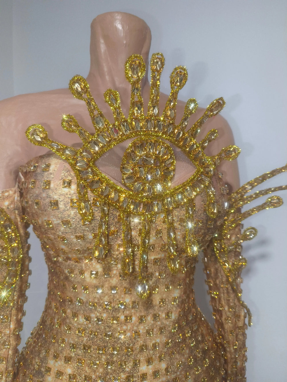 Close-up of golden eye embellishment on bodysuit