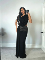 Woman taking a mirror selfie wearing a black evening gown with sequin detailing.