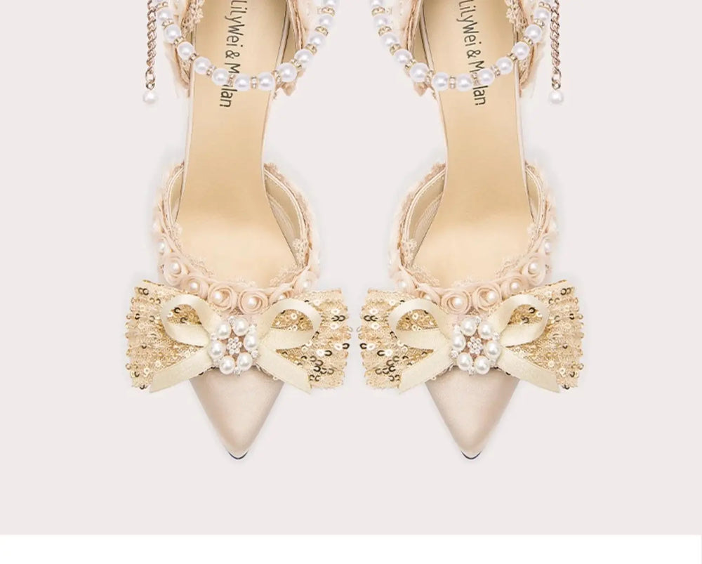 Beige high-heeled shoes with decorative bows and pearls on a white background