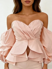 Pink strapless top with layered ruffles on a white background