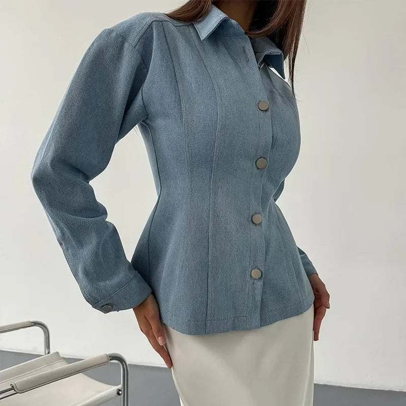 Blue denim jacket with buttons worn by a person on a plain background