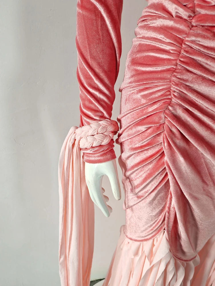 Close-up of a pink velvet dress with a white arm and hand.