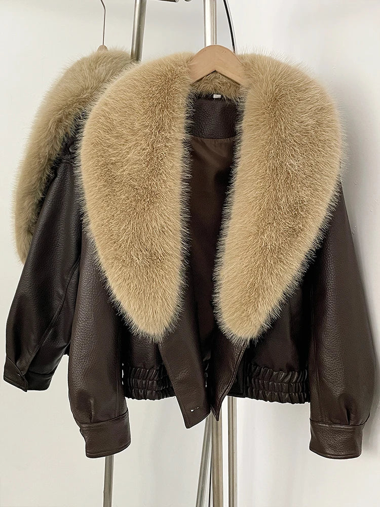 Faux leather bomber jacket with a large beige faux fur collar displayed on a hanger, detail shot