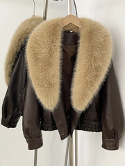 Faux leather bomber jacket with a large beige faux fur collar displayed on a hanger, detail shot