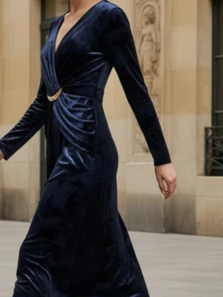 Navy velvet dress worn by a model in an indoor setting