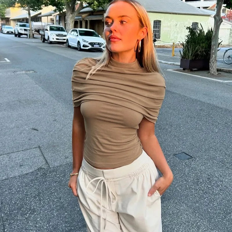 Khaki draped turtleneck short sleeve cropped top worn outdoors