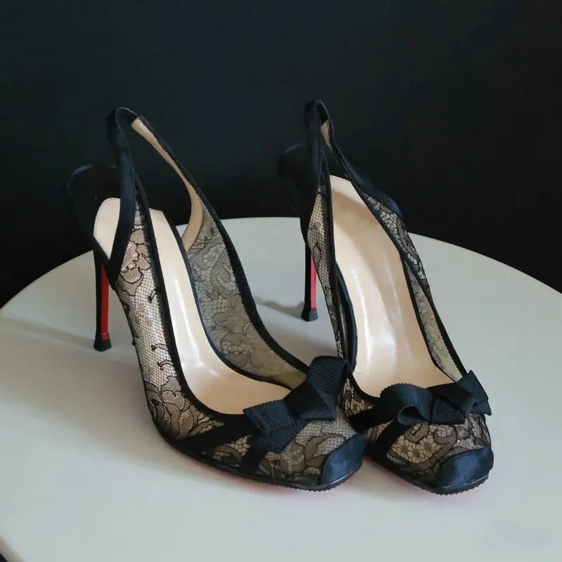 Black lace slingback heels with floral pattern and bow
