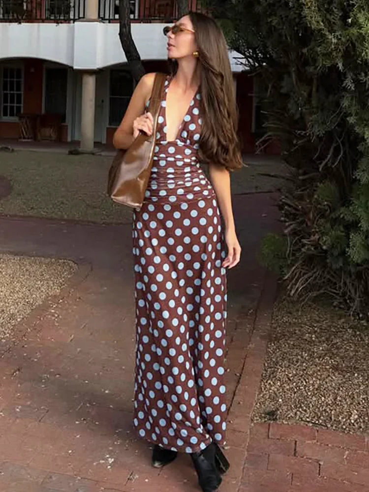 Model wearing a polka dot deep v neck halter maxi dress outdoors