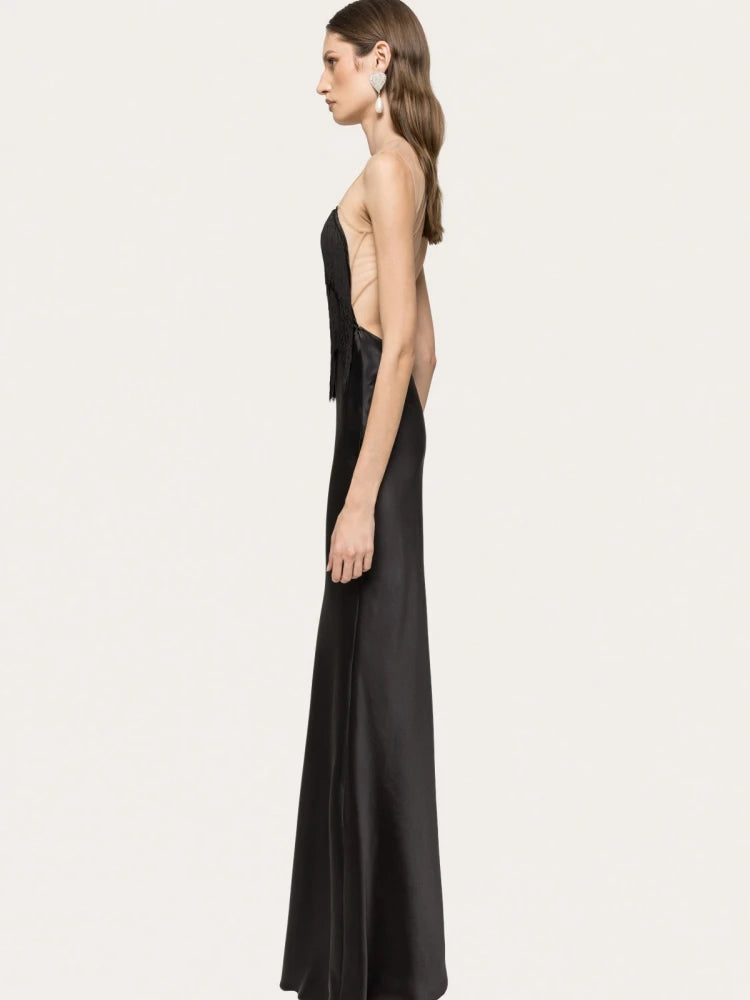 Woman wearing a black evening gown on a light gray background
