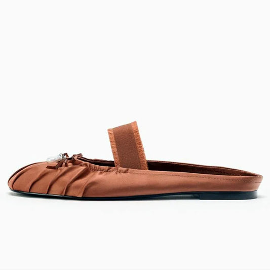 Side view of reddish brown pleated satin mule flat.