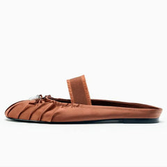 Side view of reddish brown pleated satin mule flat.