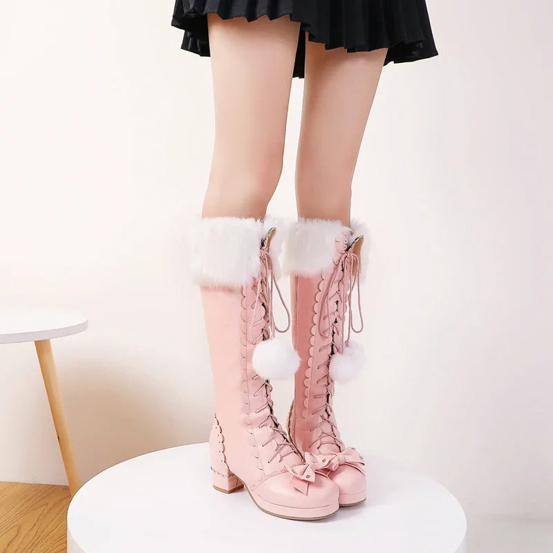 Pink knee-high boots with white fur trim on a white background
